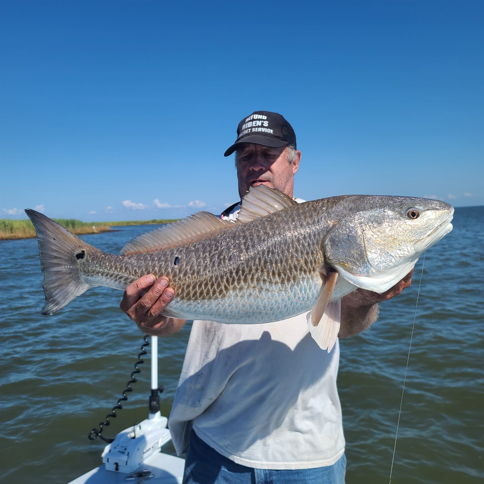 Angler holding a bull redfish on a South Louisiana fishing charter