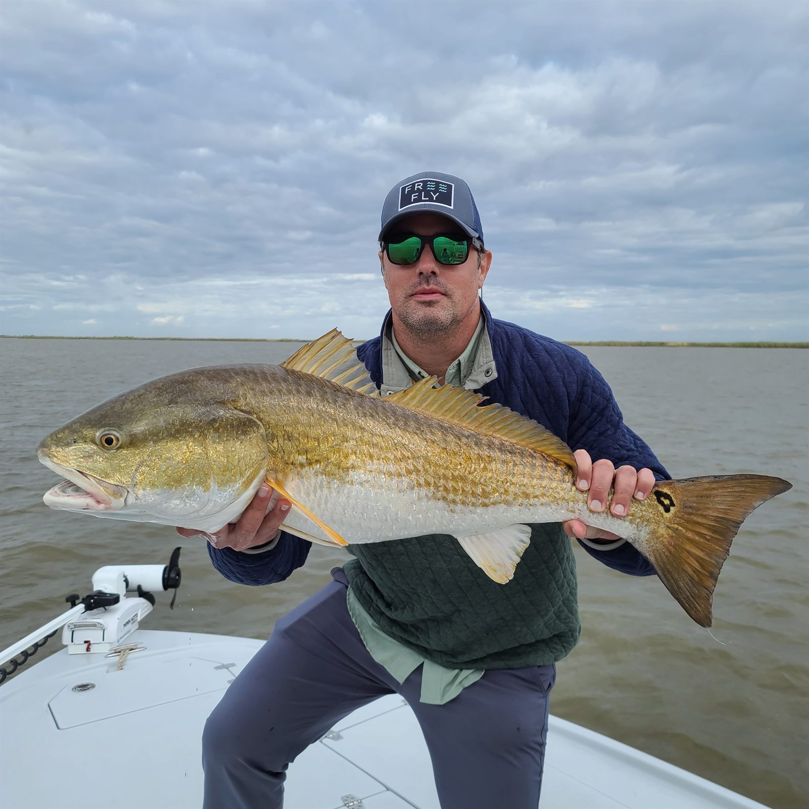 Customer posing with a bull redfish after a South Louisiana fishing charter