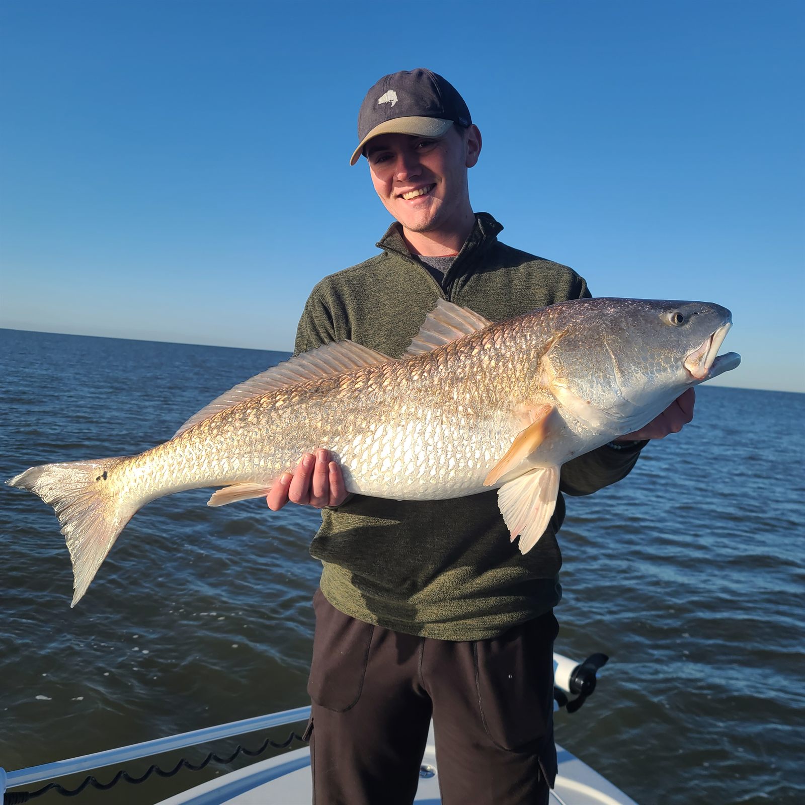 Angler holding a large redfish on a South Louisiana fishing charter
